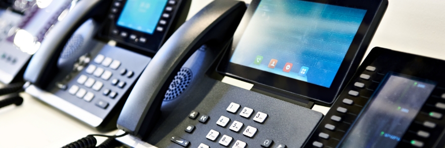 An image of office desk phones lined up in a row.